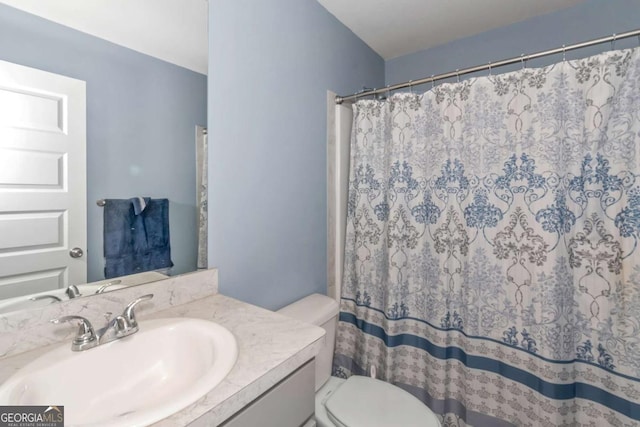 bathroom with vanity, curtained shower, and toilet