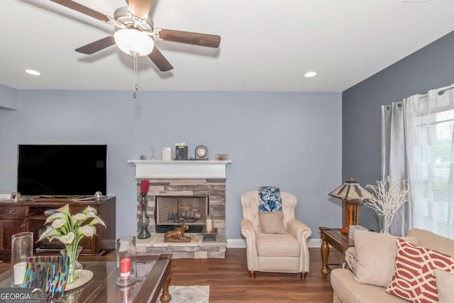 living room with ceiling fan, a fireplace, and wood-type flooring