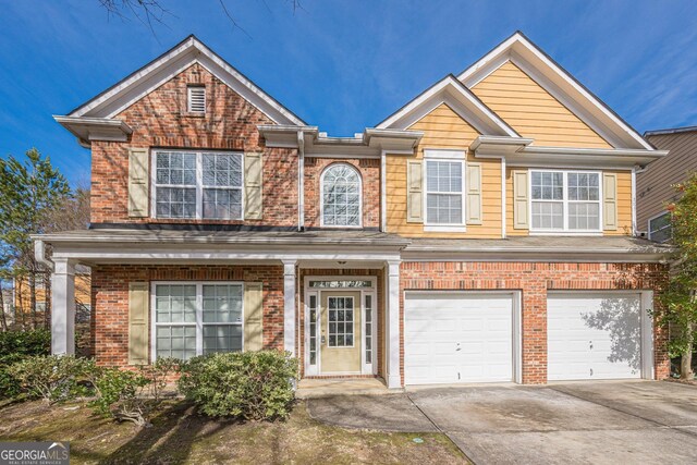 view of front of home with a garage, driveway, and brick siding