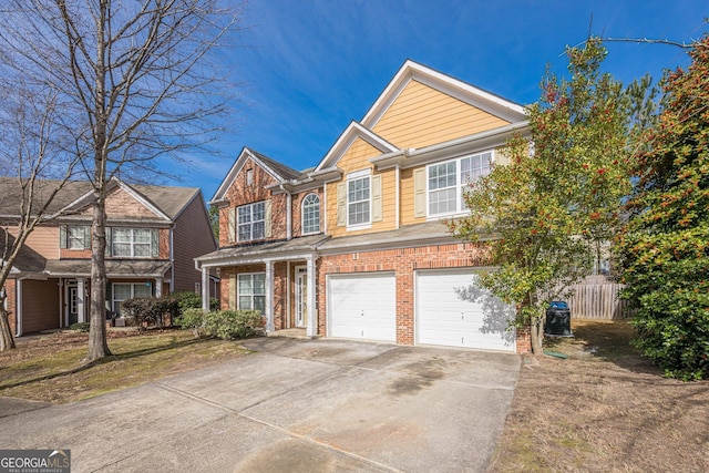 view of front of home with an attached garage, fence, brick siding, and driveway