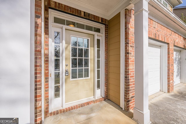 view of exterior entry featuring brick siding, a porch, and an attached garage