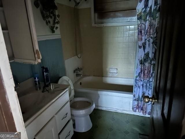 full bathroom featuring tile patterned floors, shower / bath combo with shower curtain, vanity, and toilet