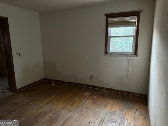 unfurnished room with dark wood-type flooring