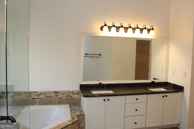 bathroom featuring vanity and tiled tub