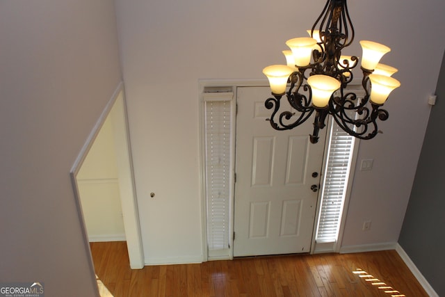 entryway featuring hardwood / wood-style flooring and a notable chandelier