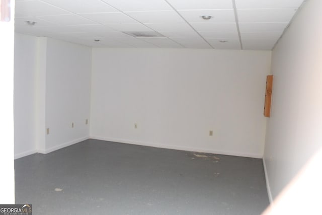 unfurnished room featuring a drop ceiling and concrete floors