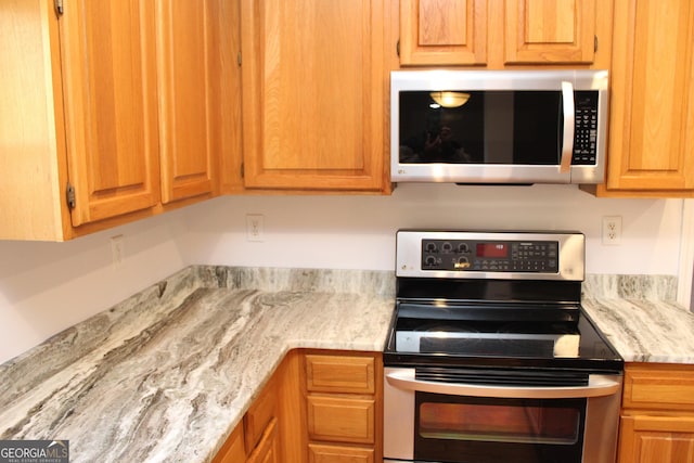 kitchen featuring light stone countertops and appliances with stainless steel finishes