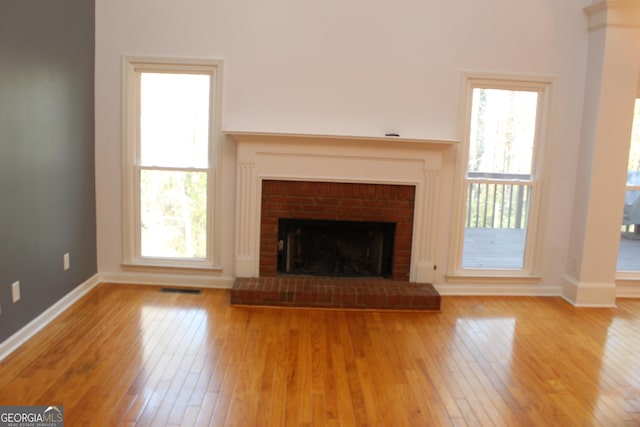 unfurnished living room featuring a fireplace and light hardwood / wood-style flooring