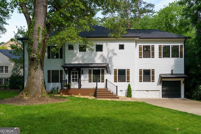 view of front of home with covered porch, a front yard, and a garage