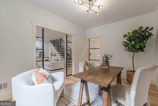 living area featuring light hardwood / wood-style floors and an inviting chandelier