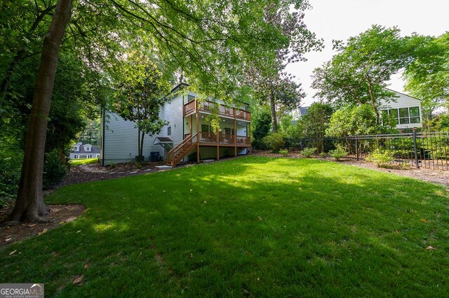 rear view of property with a lawn and a wooden deck