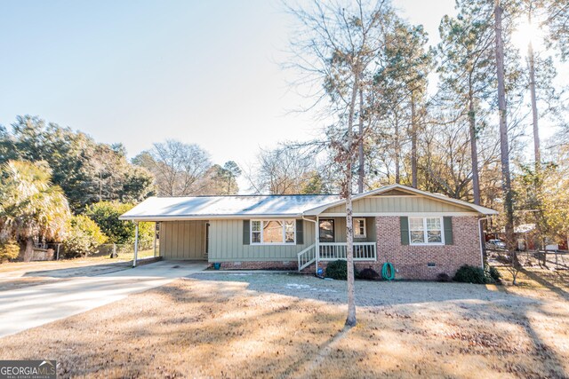 single story home featuring a carport, a porch, and a front lawn