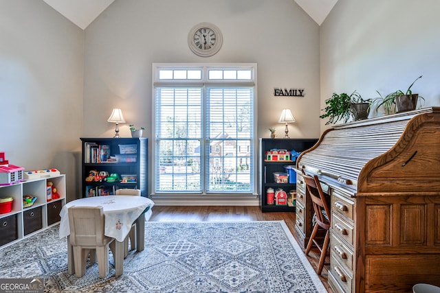 game room with hardwood / wood-style floors and vaulted ceiling