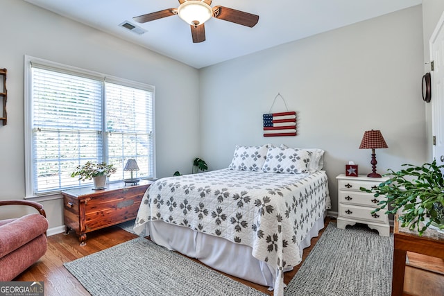 bedroom with multiple windows, hardwood / wood-style flooring, and ceiling fan