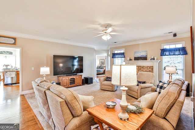 living room with ceiling fan, light wood-type flooring, and ornamental molding