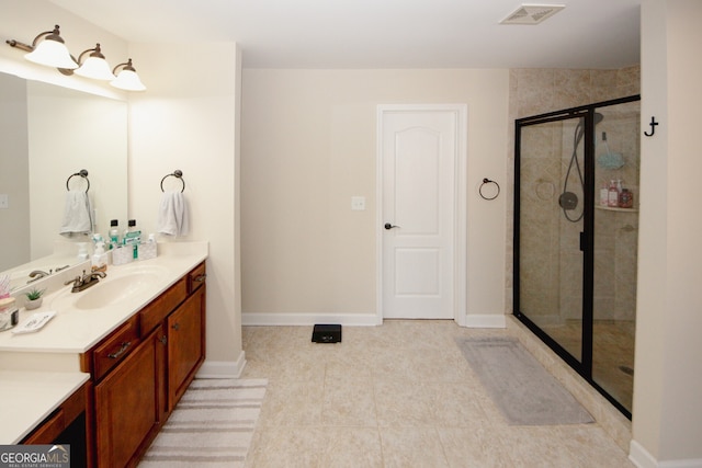 bathroom with tile patterned flooring, vanity, and walk in shower