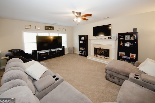 carpeted living room with ceiling fan