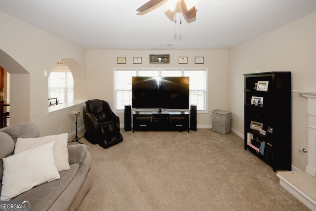 living room with ceiling fan, light carpet, and a wealth of natural light