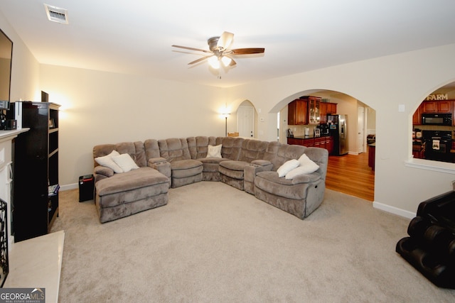 carpeted living room with ceiling fan