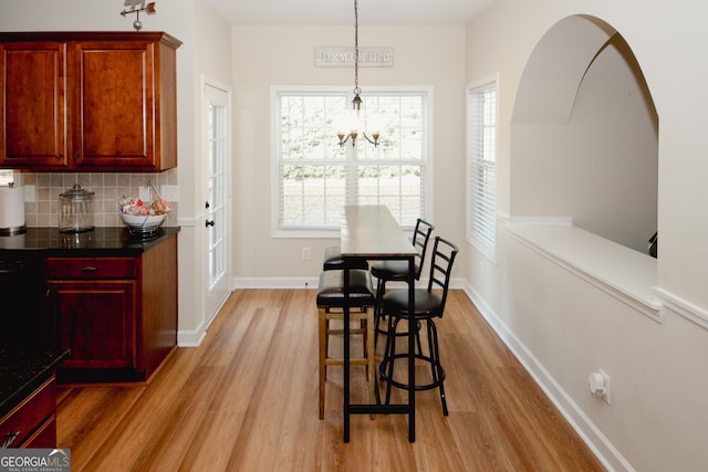 dining area featuring light wood-type flooring and an inviting chandelier