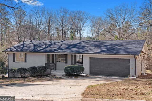 ranch-style home featuring covered porch and a garage