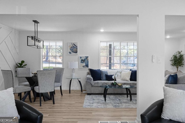 living room featuring a chandelier and light hardwood / wood-style floors