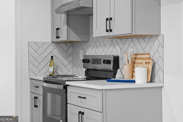 kitchen with tasteful backsplash, electric range, white cabinets, and extractor fan