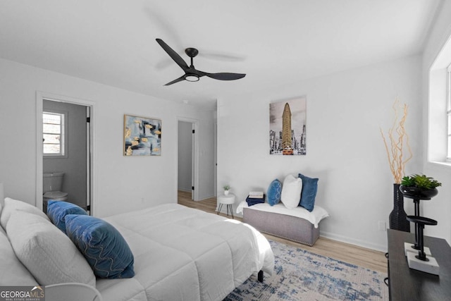 bedroom with ensuite bathroom, ceiling fan, and wood-type flooring