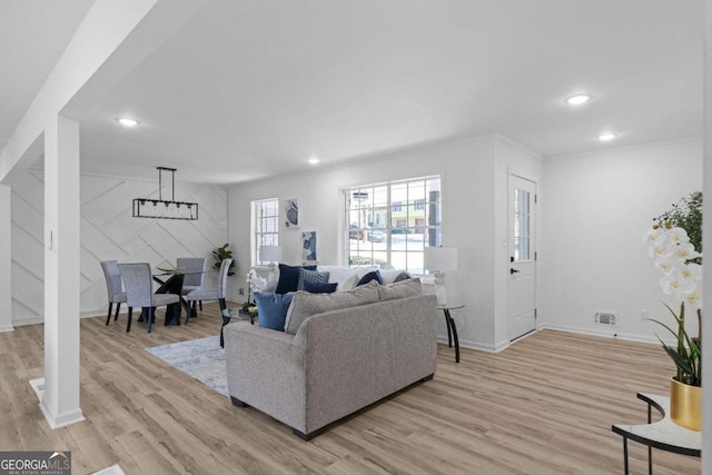 living room with light hardwood / wood-style flooring and ornamental molding