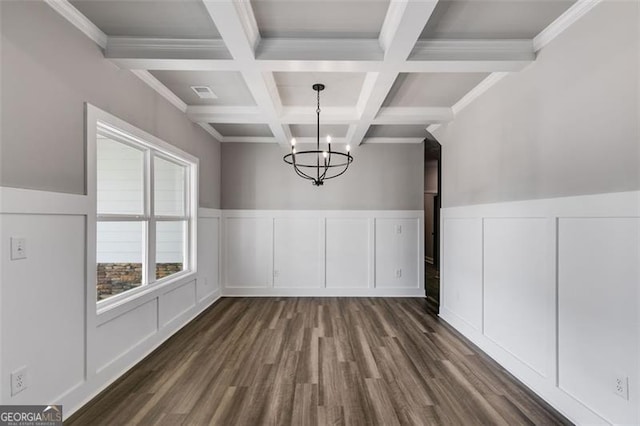 unfurnished dining area featuring dark wood-type flooring, coffered ceiling, beamed ceiling, a notable chandelier, and ornamental molding