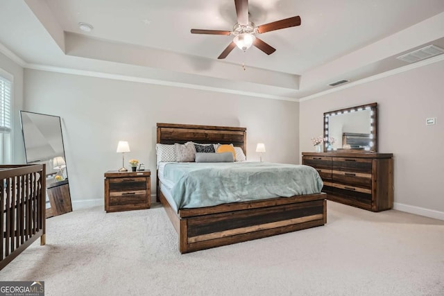 carpeted bedroom with ceiling fan, a raised ceiling, and crown molding