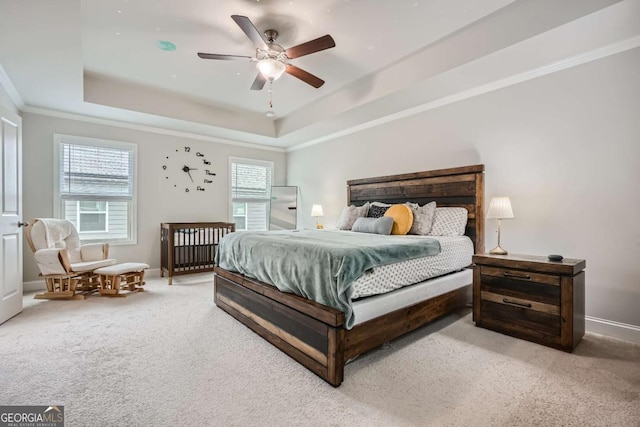 bedroom with multiple windows, carpet, a raised ceiling, and ceiling fan