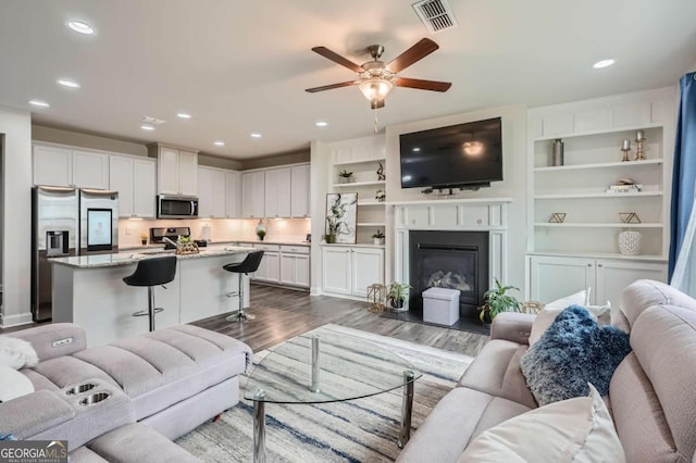 living room with dark hardwood / wood-style floors and ceiling fan