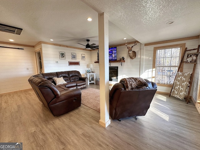 living room with wood walls, hardwood / wood-style floors, and a textured ceiling