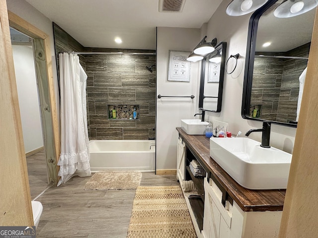 bathroom featuring shower / bathtub combination with curtain, vanity, and wood-type flooring