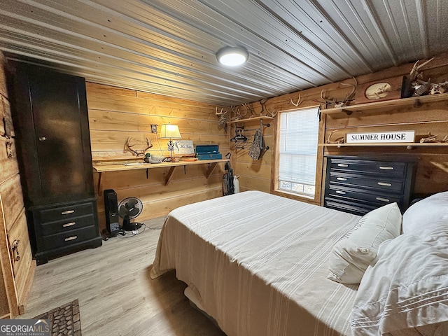 bedroom with wooden walls, wood ceiling, and light hardwood / wood-style floors