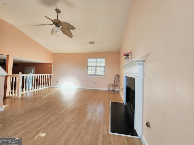 unfurnished living room featuring light wood-type flooring, a fireplace, a ceiling fan, and baseboards