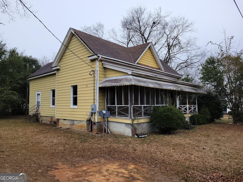 view of home's exterior with a sunroom