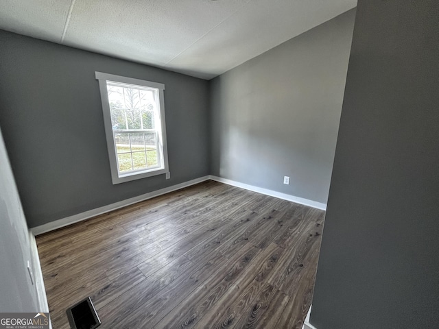 spare room featuring dark hardwood / wood-style flooring