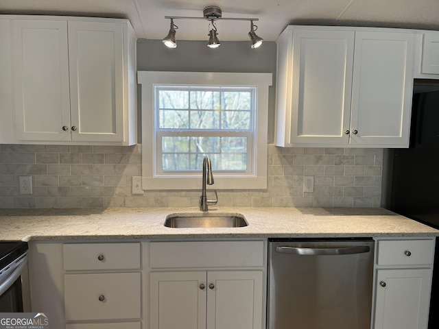 kitchen with white cabinets, backsplash, stainless steel dishwasher, and sink