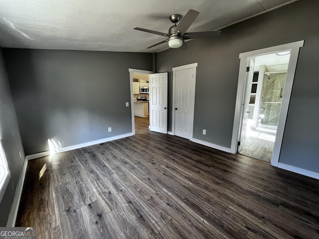 unfurnished bedroom with ceiling fan, dark hardwood / wood-style flooring, and a textured ceiling