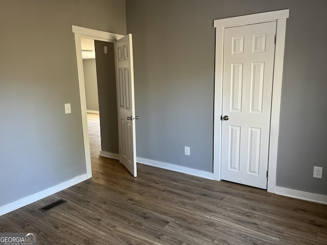 unfurnished bedroom featuring dark hardwood / wood-style flooring