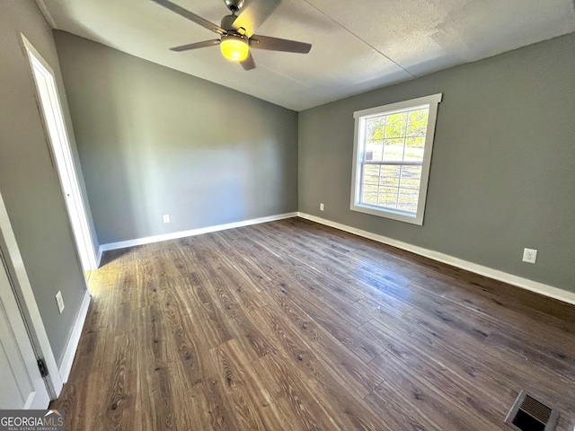 empty room with a textured ceiling, ceiling fan, and dark wood-type flooring