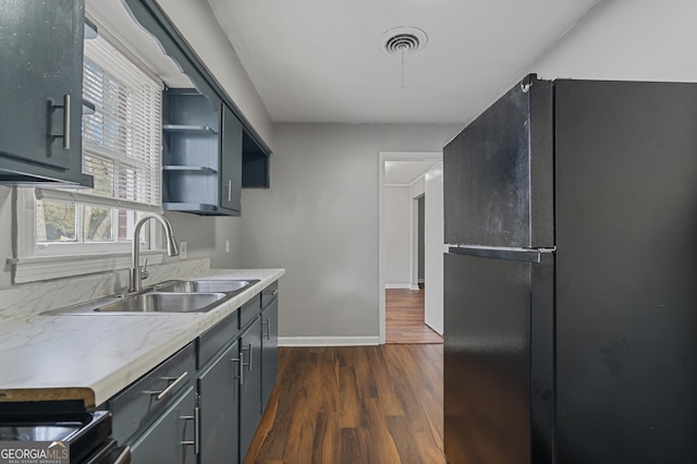 kitchen with black fridge, sink, and dark wood-type flooring