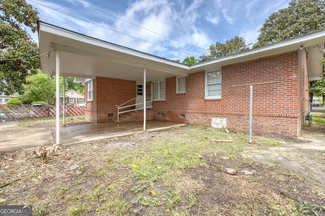 back of house featuring a carport