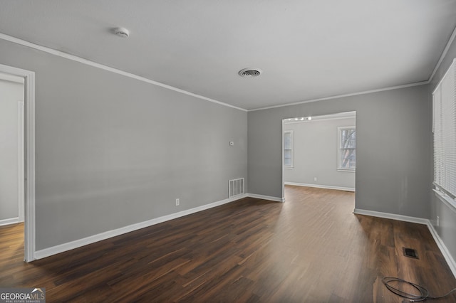 empty room with ornamental molding and dark hardwood / wood-style floors