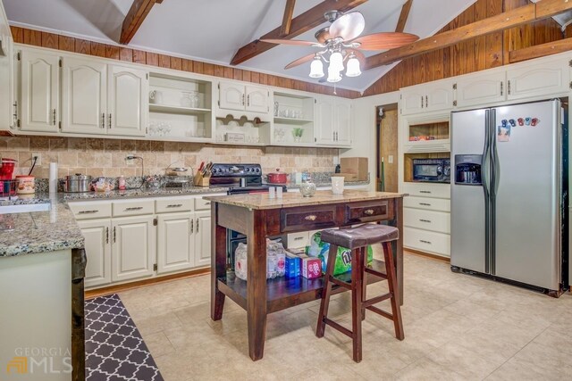 kitchen with white cabinetry, stainless steel fridge, wooden walls, ceiling fan, and beam ceiling