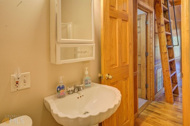 bathroom with toilet, tile patterned floors, sink, and a shower with door