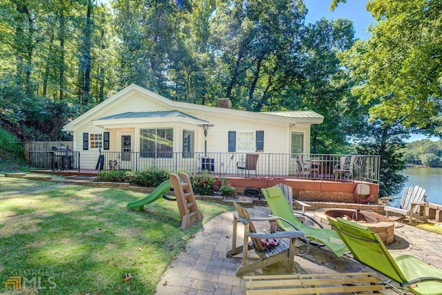 view of front facade with a patio area, a front lawn, and a fire pit