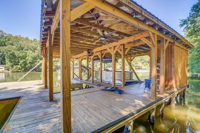 dock area with a hot tub and a water view